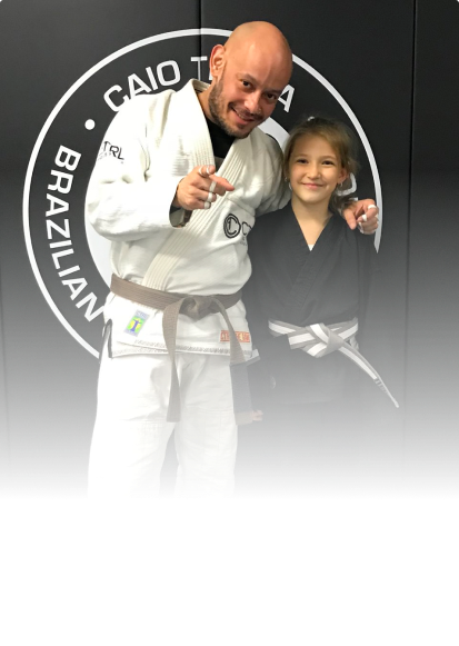 A child earning her belt in martial arts with instructor Joel Burgos at JMA BKNY.